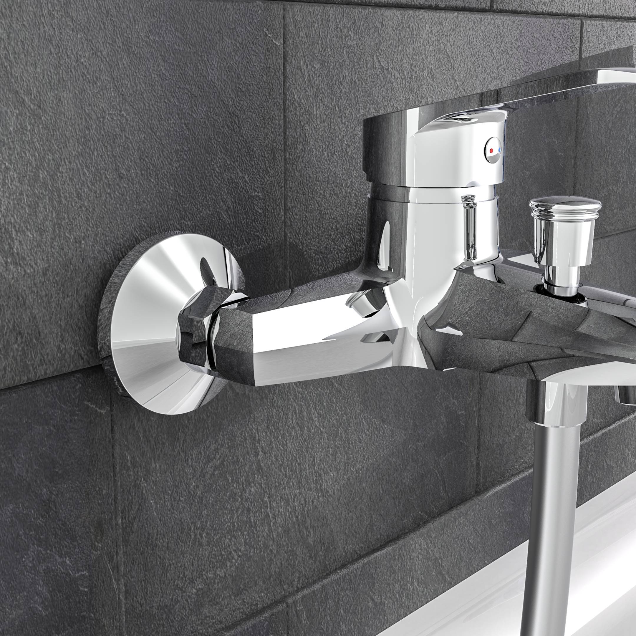 Chrom-Wandbatterie für Badewanne mit Umschalter und Handbrausenverbindung an dunkler gekachelter Wand.