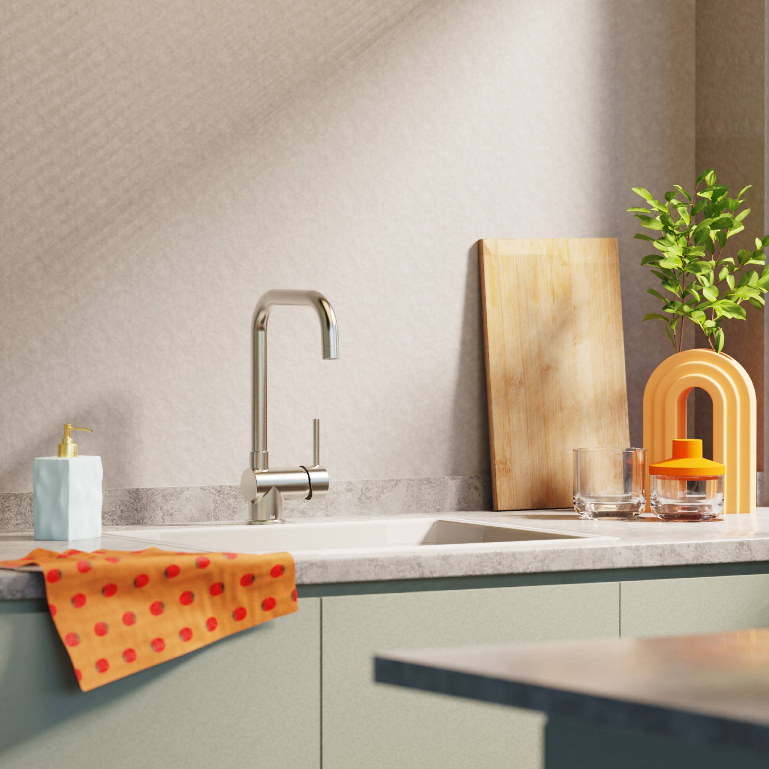 Moderne Küchenarbeitsplatte mit einem silbernen Wasserhahn, einem Holzschneidebrett, einer kleinen Pflanze und einem orangefarbenen Handtuch mit Polka-Punkten.