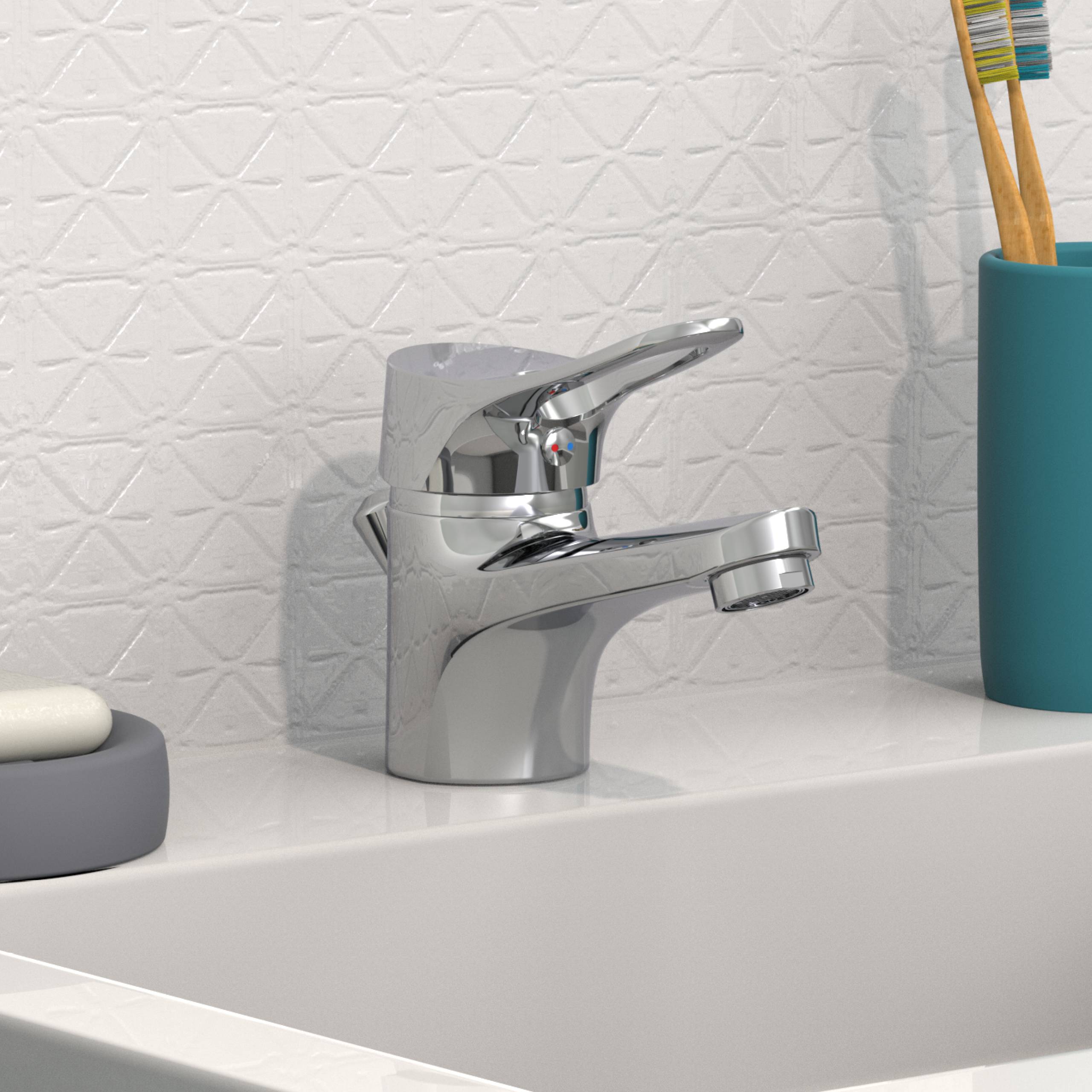 Ein glänzender Chromhahn über einem weißen Waschbecken, mit einem blauen Zahnbürstenhalter und einer Seifenschale auf einer strukturierten, hellfarben Badezimmerarbeitsplatte.