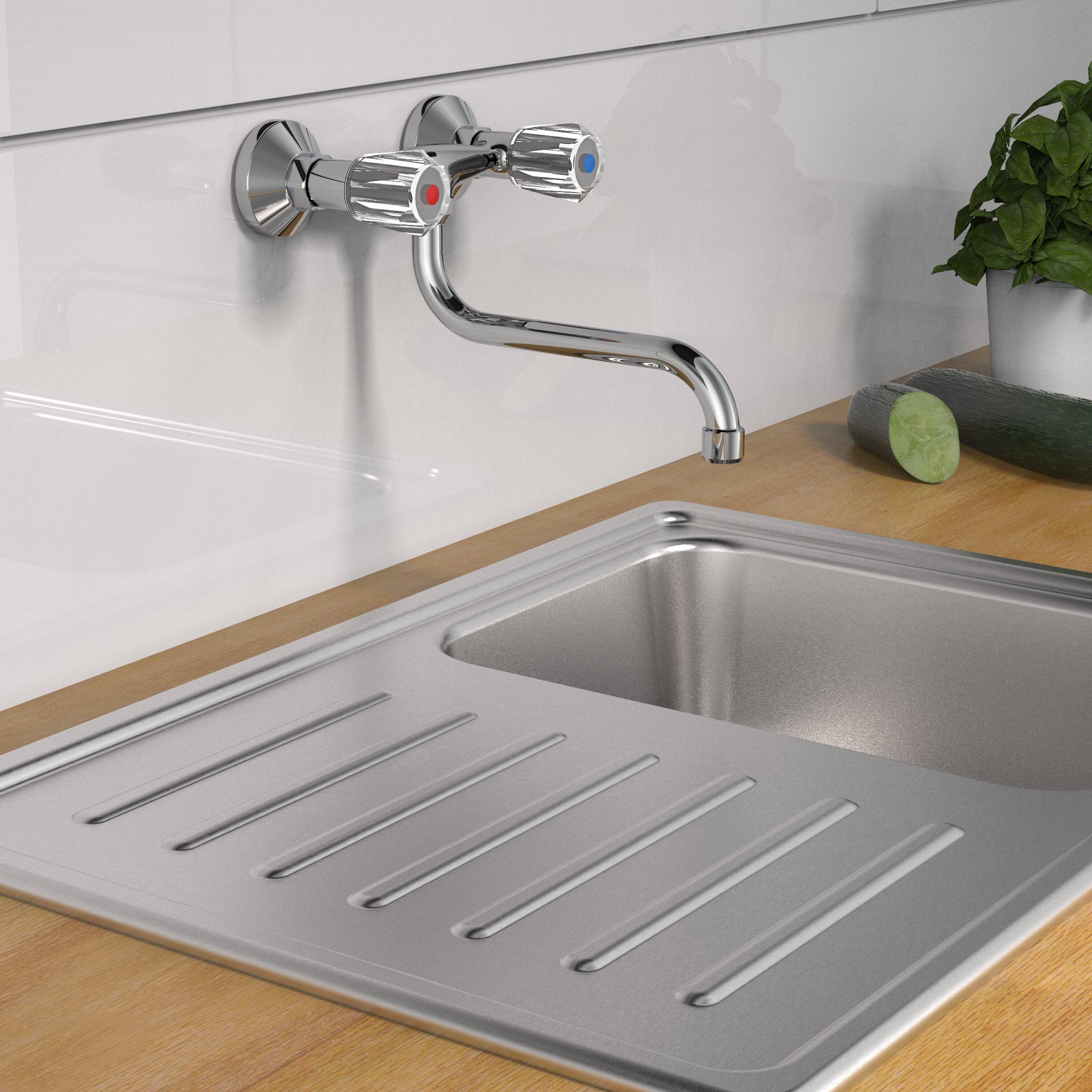Ein Edelstahlküchenspülbecken mit angebrachtem Abtropfbrett ist unter einem Wandwasserhahn montiert, neben einem Schneidbrett und einer grünen Pflanze.