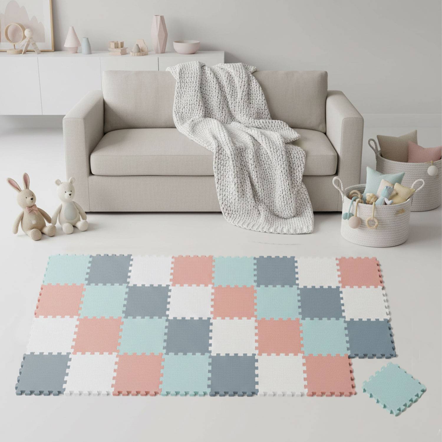 Ein gemütliches Wohnzimmer mit einem weißen Sofa, einer darüber gelegten gestrickten Decke, einem Spielzeugkorb und einer bunten zusammenhängenden Bodenmatte.