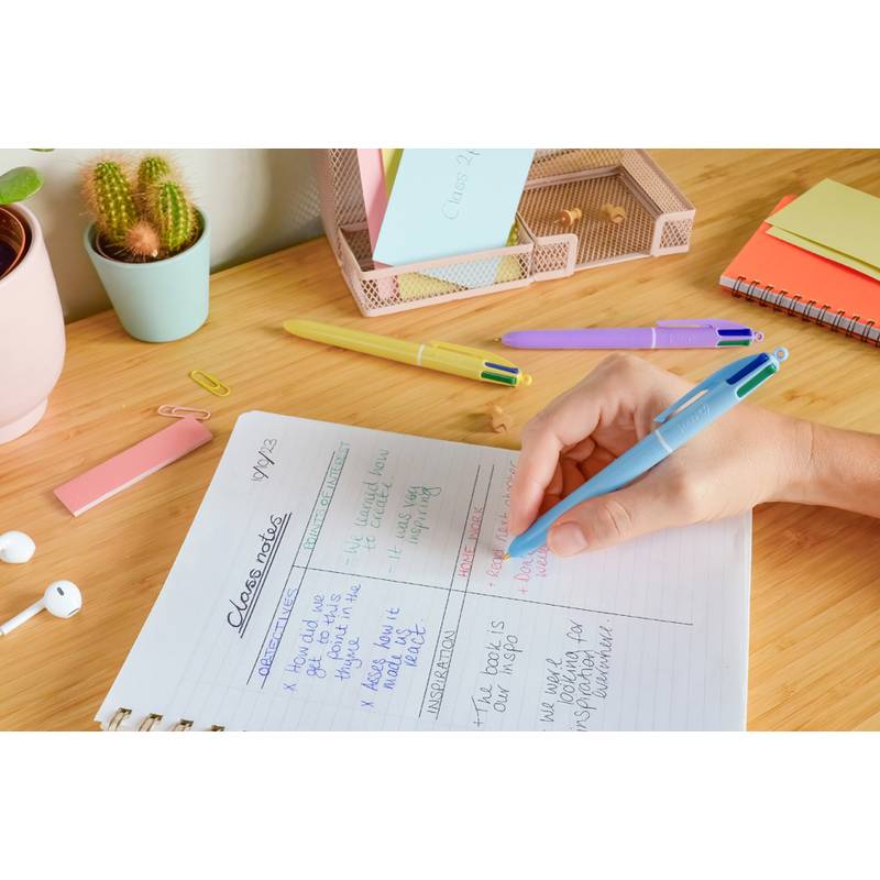 Eine Person schreibt mit einem blauen Stift in ein Notizbuch mit der Aufschrift 