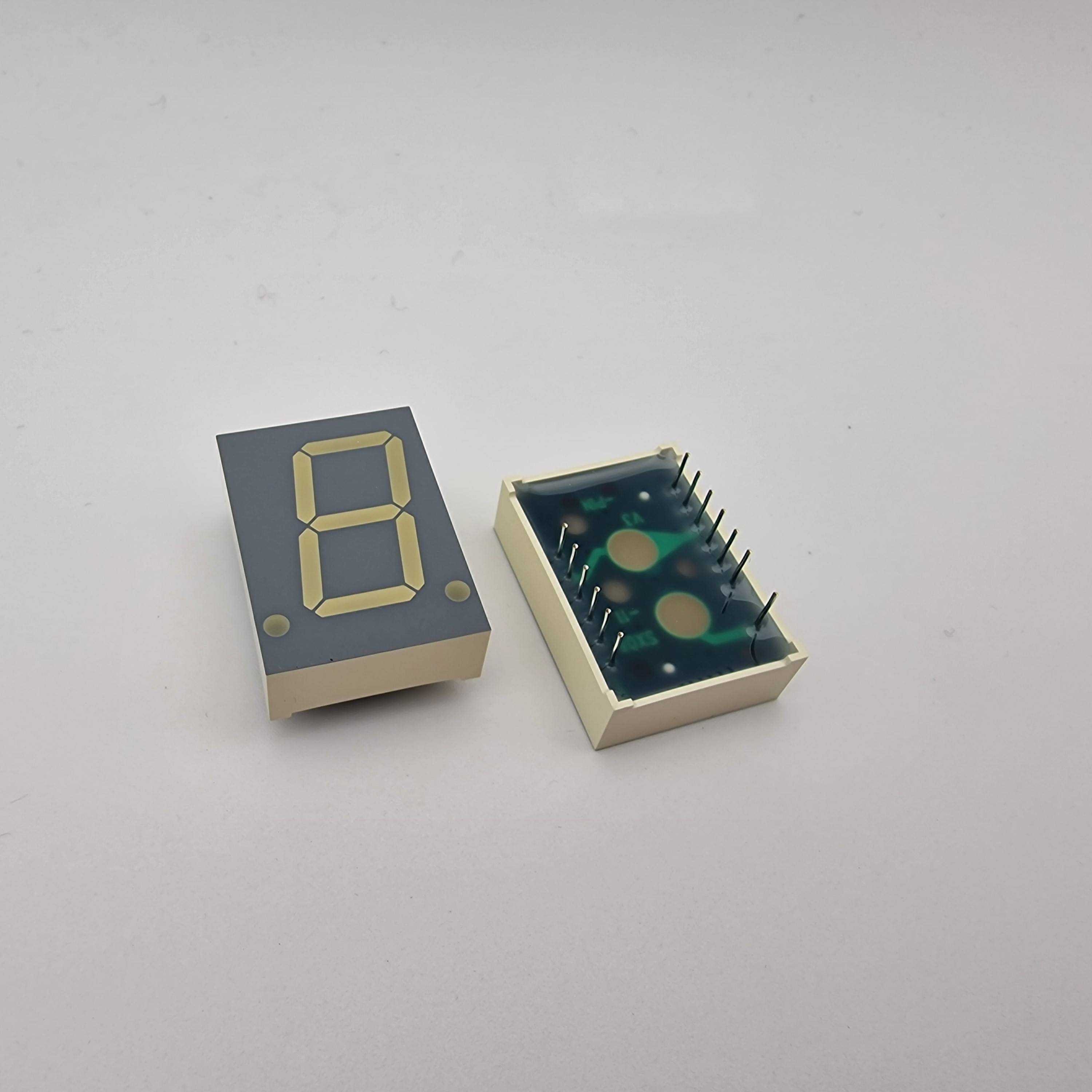 Ein grauer Sieben-Segment-LED-Anzeige, die die Zahl '8' zeigt, neben seiner Rückansicht mit Schaltkreis-Pins vor einem einfarbigen Hintergrund.