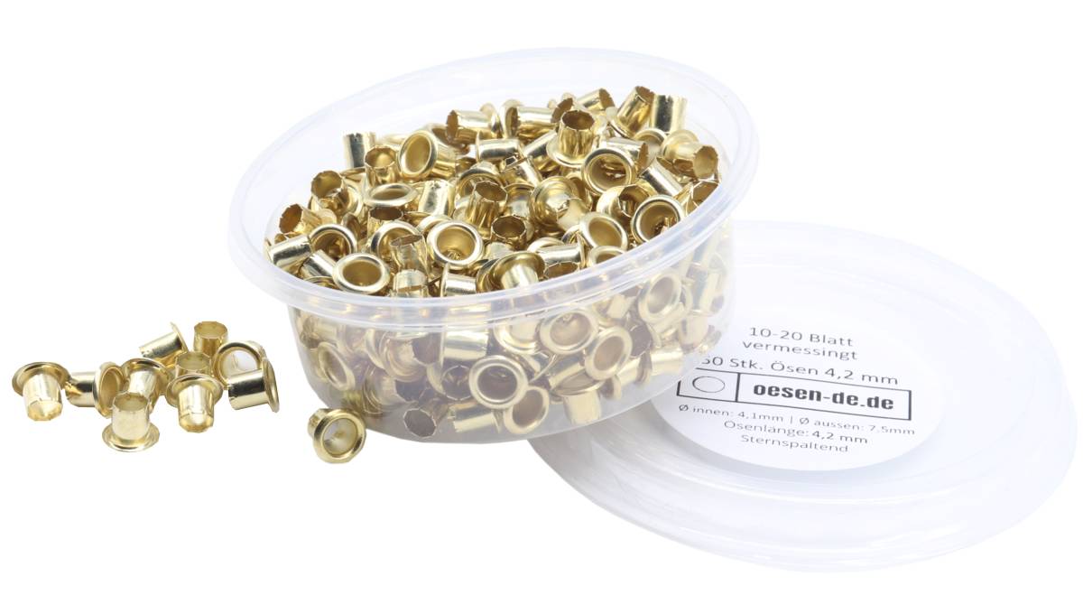 Ein durchsichtiger Plastikbehälter gefüllt mit glänzenden, runden Messingösen; der Deckel zeigt Produktdetails in deutscher Schrift.