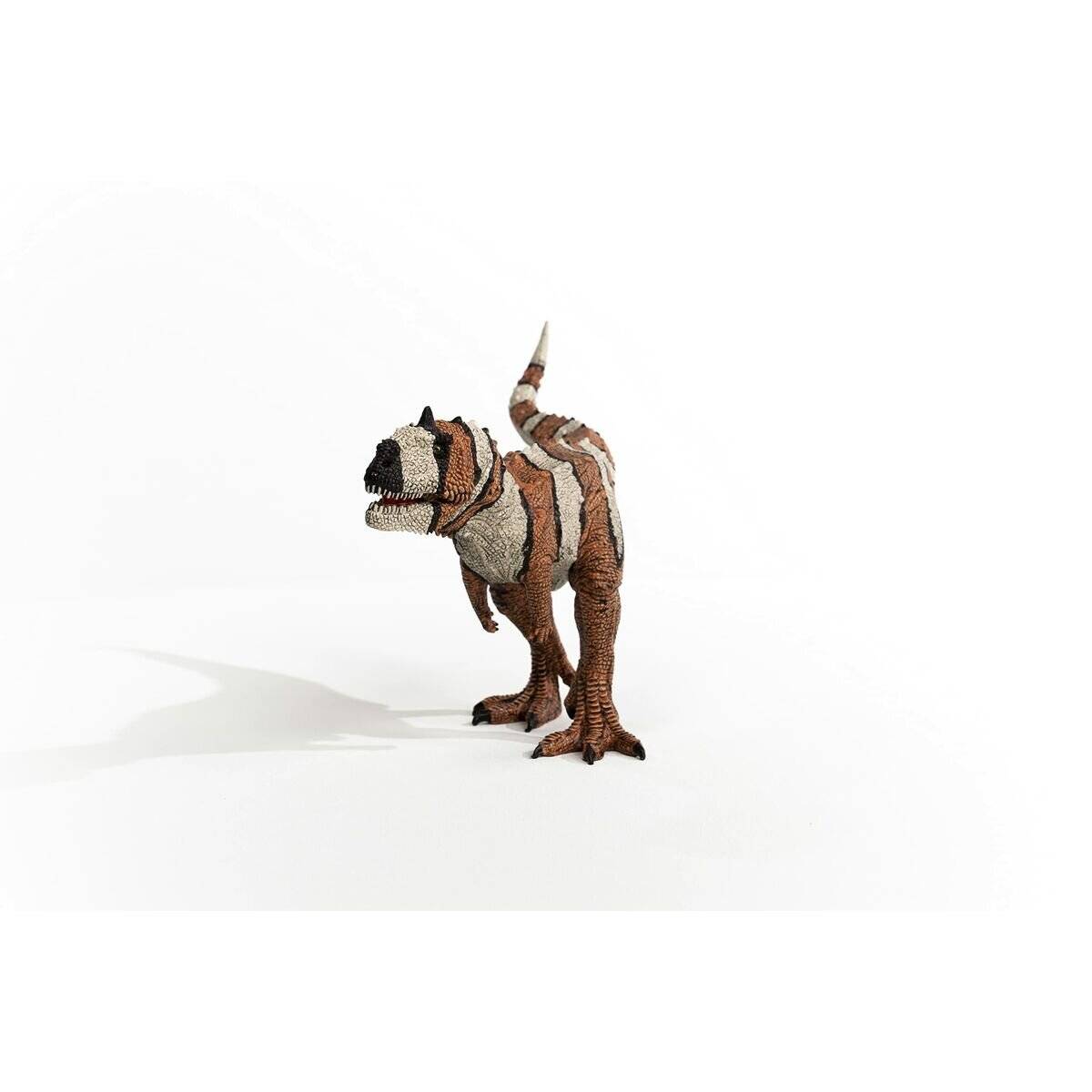 Eine braune und beige Spielzeug-Dinosaurierfigur steht auf weißem Hintergrund, blickt nach links mit erhobenen Schwanz.