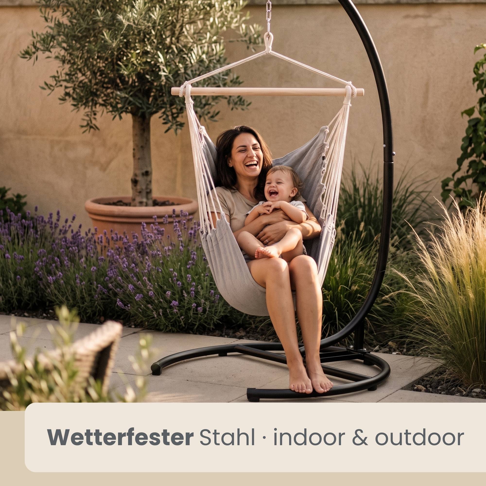 Frau lächelnd mit einem Baby in einem hängenden Stuhl im Freien; Text lautet „Wetterfester Stahl · indoor & outdoor