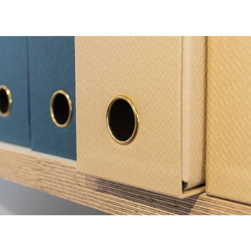 Eine Nahaufnahme von blauen und beigen Aktenkisten mit kreisförmigen Griffen auf einem Holzregal, die ihre strukturierten Oberflächen hervorhebt.