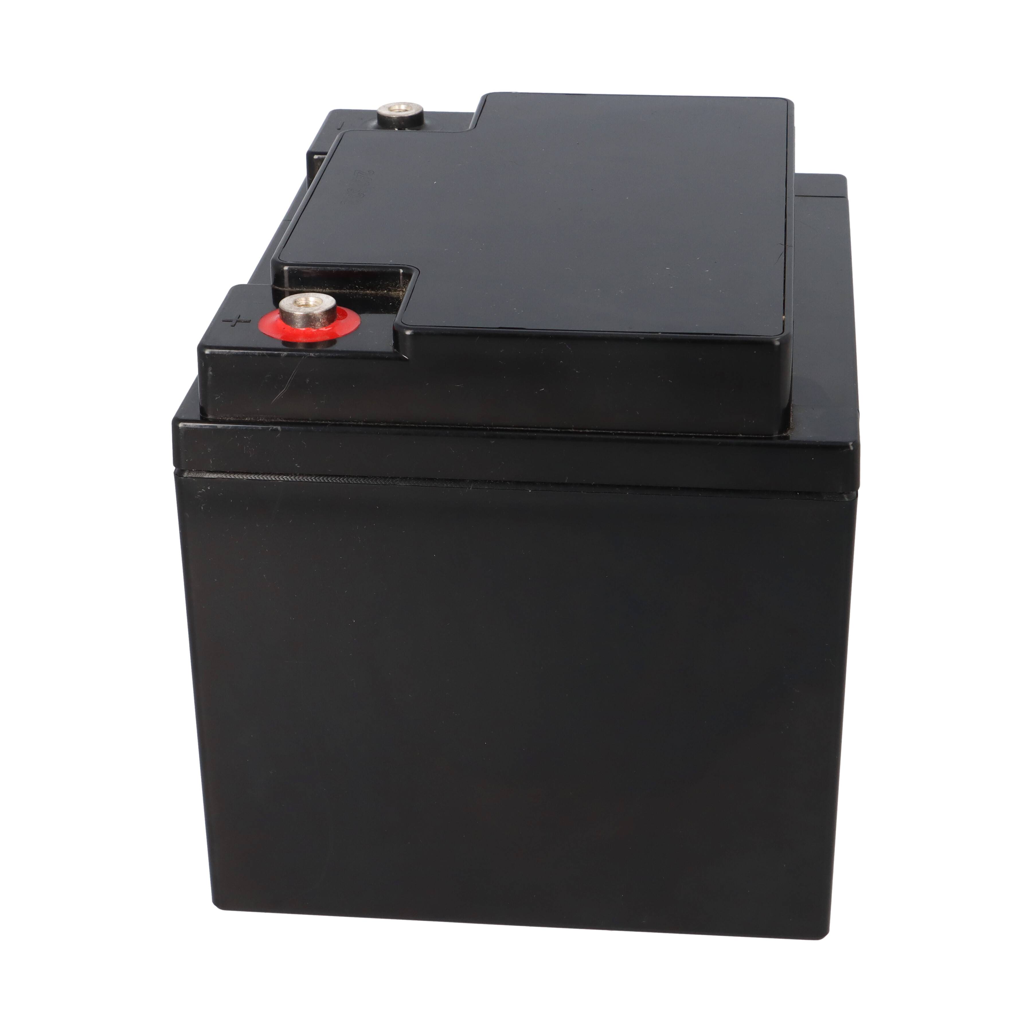 Eine schwarze rechteckige Autobatterie mit einem positiven und negativen Anschluss oben, konstruiert für den Automobileinsatz.