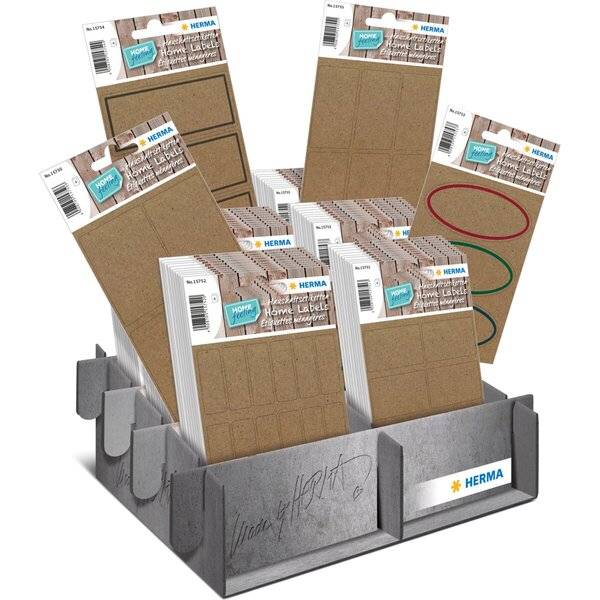 Displaybox mit HERMA Heimat-Etikettensticker-Paketen in verschiedenen Größen und Farben, aufrecht in einer grauen Karton-Thekendisplay angeordnet.