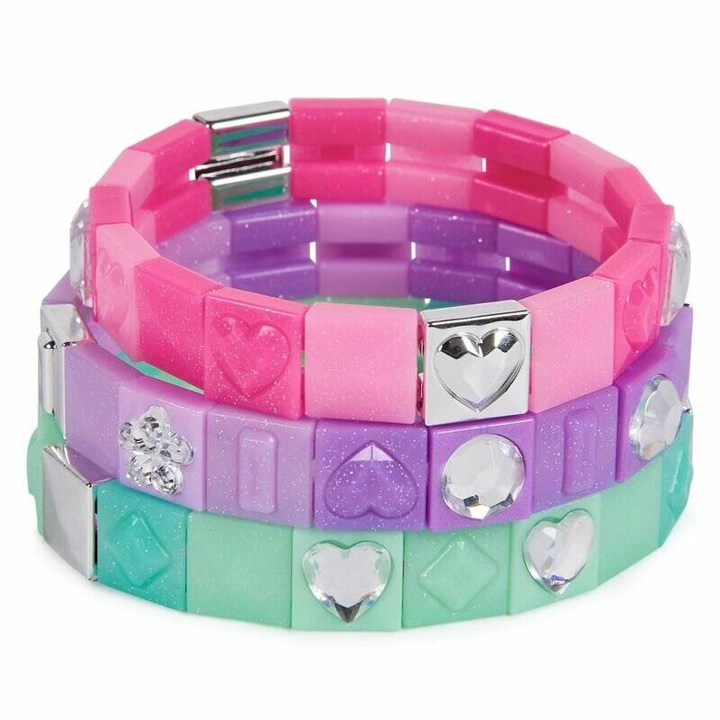 Stapel von bunten dehnbaren Armbändern mit herzförmigen und edelsteinähnlichen Verzierungen auf weißem Hintergrund.