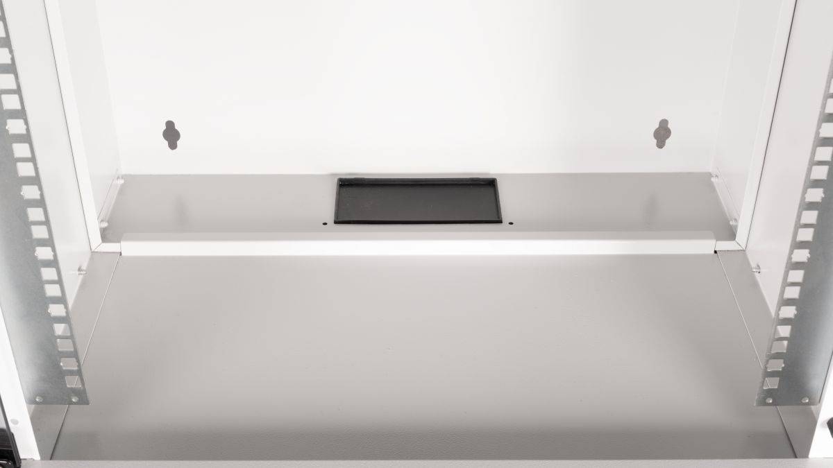 Innenseite eines weißen Metallschranks oder Serverracks mit einem leeren unteren Fach mit einer zentrierten rechteckigen Öffnung auf der Rückwand.