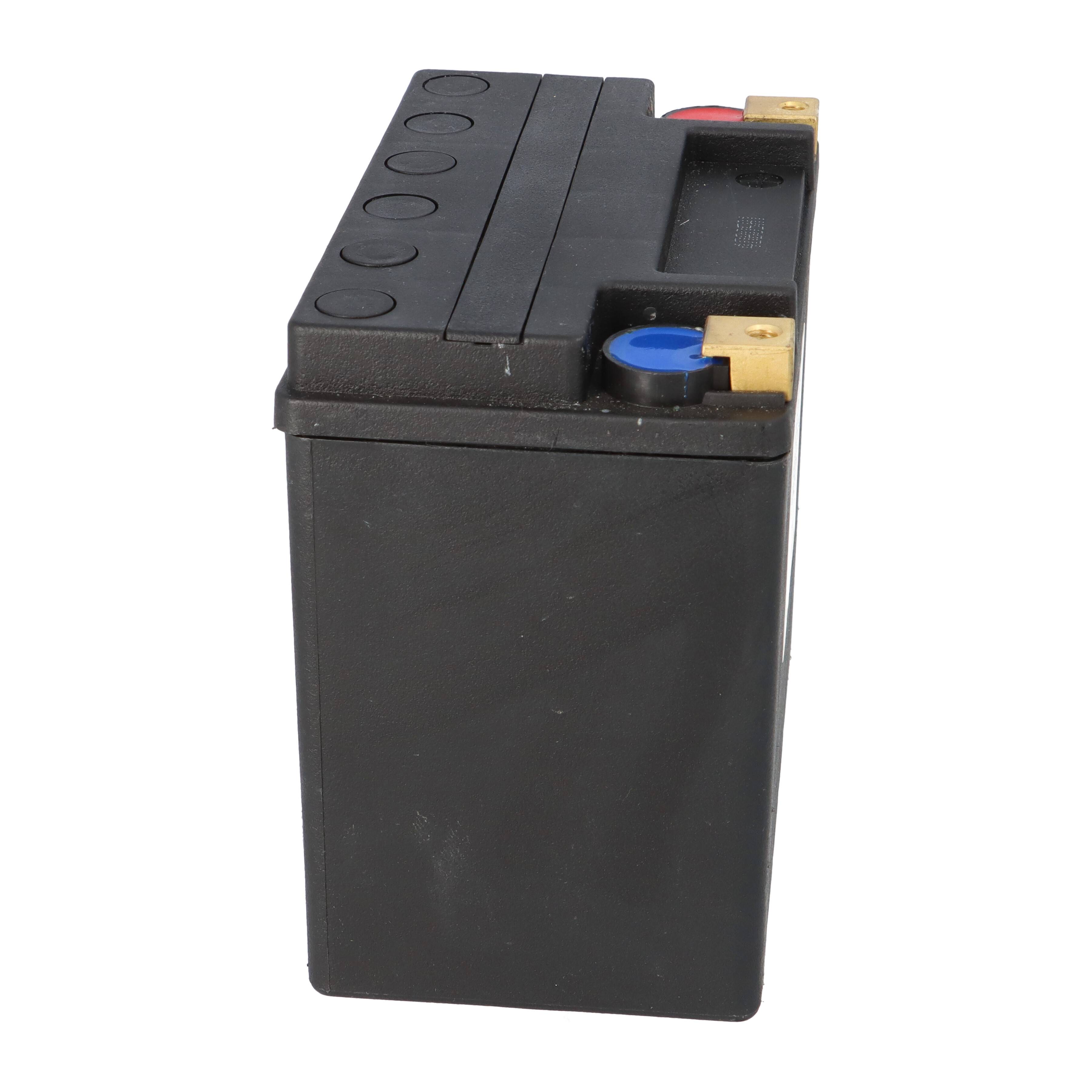 Eine schwarze Autobatterie mit sichtbaren roten und blauen Anschlüssen oben, die positive und negative Verbindungen anzeigen.