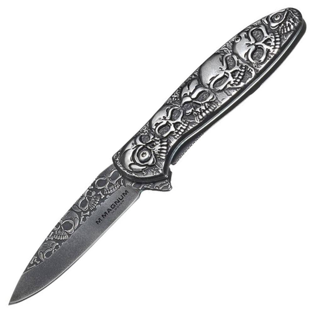 Dekoratives Klappmesser mit Totenkopf-gemustertem Griff und gravierter Klinge auf weißem Hintergrund.