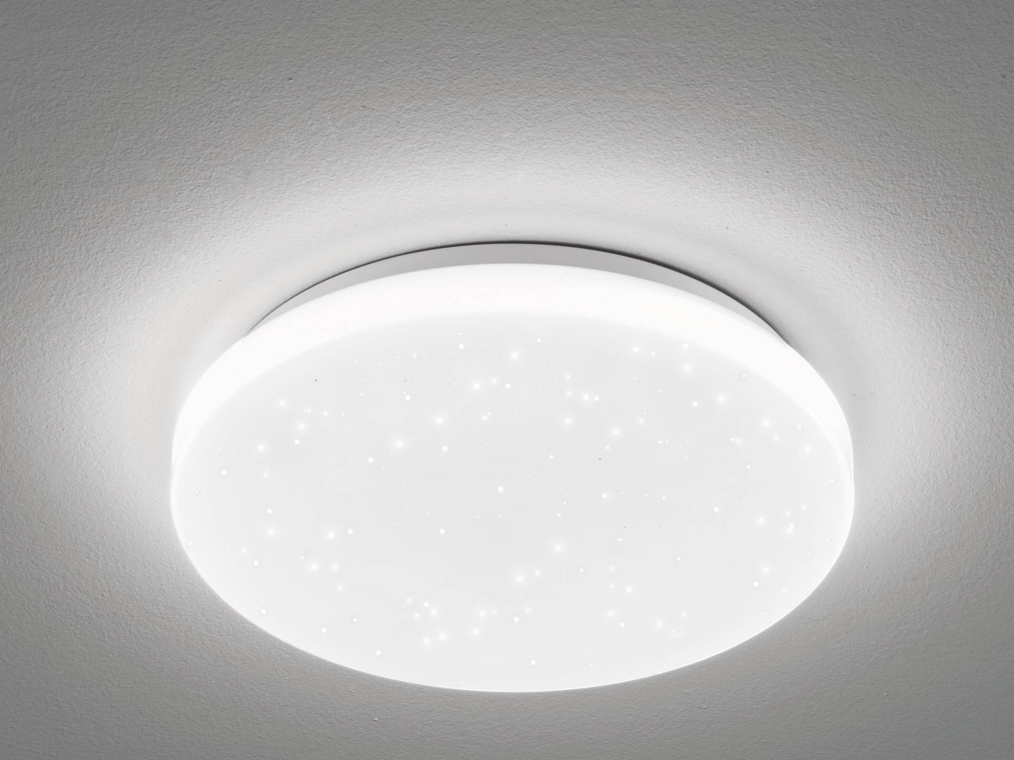 Eine runde Deckenleuchte mit glatter, weißer Oberfläche und winzigen Flecken, die Sternen ähneln, die ein weiches, gleichmäßiges Licht abgibt.
