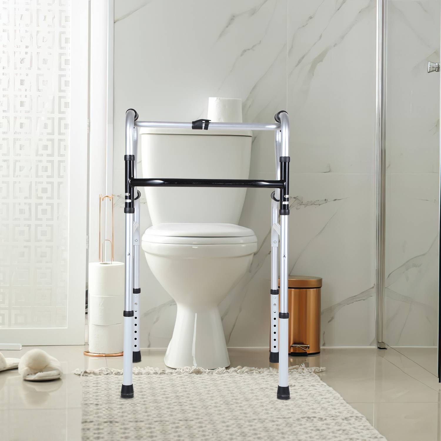 Badezimmertoilette mit einem silbernen und schwarzen Toilettensicherheitsrahmen/Toilettengeh-Hilfe, der davor auf einem Teppich positioniert ist.