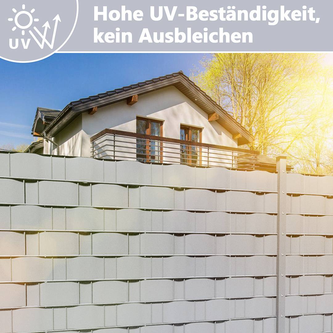 Weiße Zaunelemente vor einem Haus, mit deutschem Text, der besagt „Hohe UV-Beständigkeit, keine Verblassung".