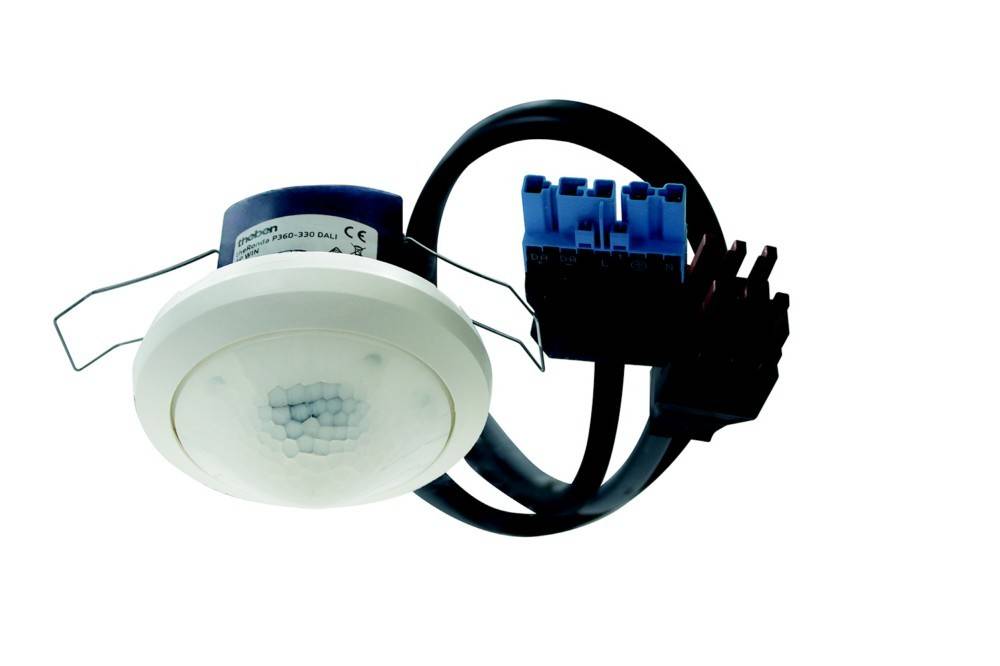 Deckenmontierter Bewegungssensor mit einer weißen kreisförmigen Gestaltung und einem blauen Leitungsanschluss, vorgesehen für den Einsatz in Beleuchtungssystemen.