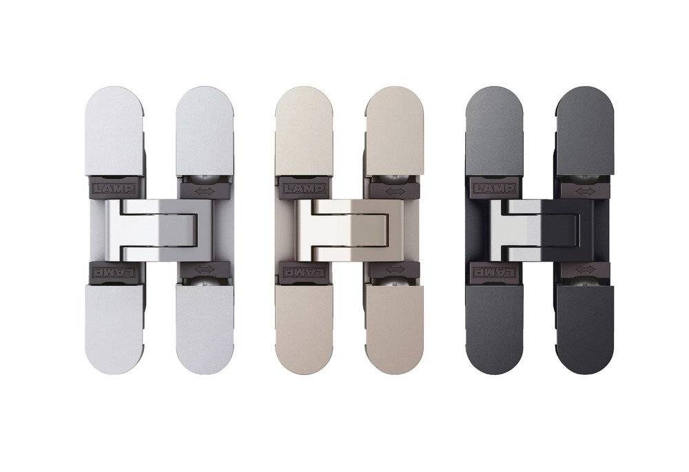 Drei verdeckte Scharniere, jeweils in unterschiedlichen Metalloberflächen: silber, beige und schwarz, in einer Reihe gegen einen weißen Hintergrund angeordnet.