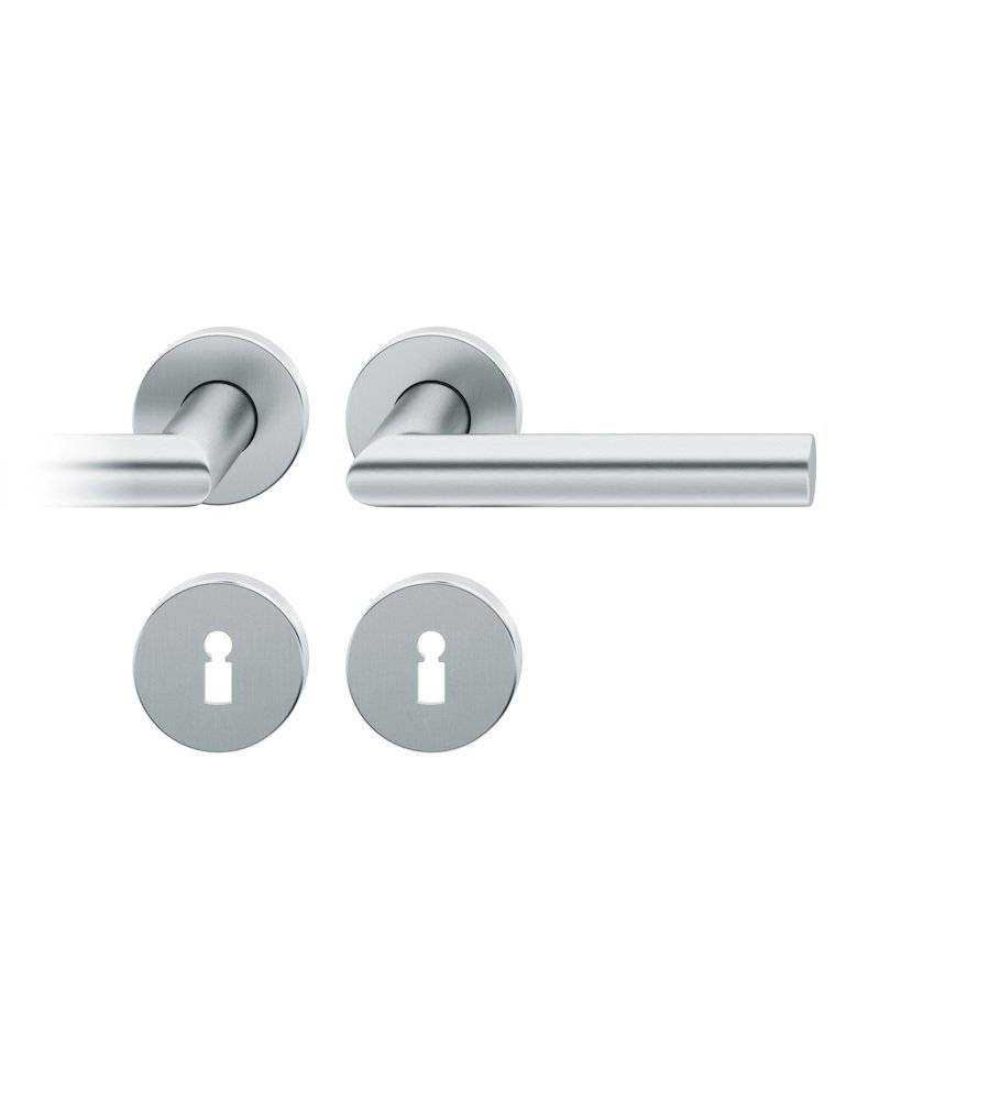 Ein rechteckiger Schwammblock liegt neben einer Metallmutter auf weißem Hintergrund und hebt die kontrastierenden Texturen und Materialien hervor.