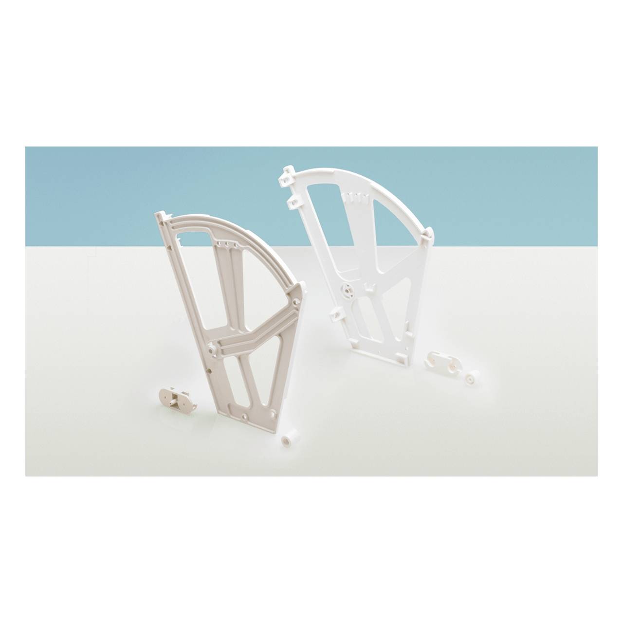 Zwei weiße Kunststoffkomponenten stehen aufrecht auf einer hellen Oberfläche mit einigen kleinen abnehmbaren Teilen in der Nähe, vor einem blauen Hintergrund.