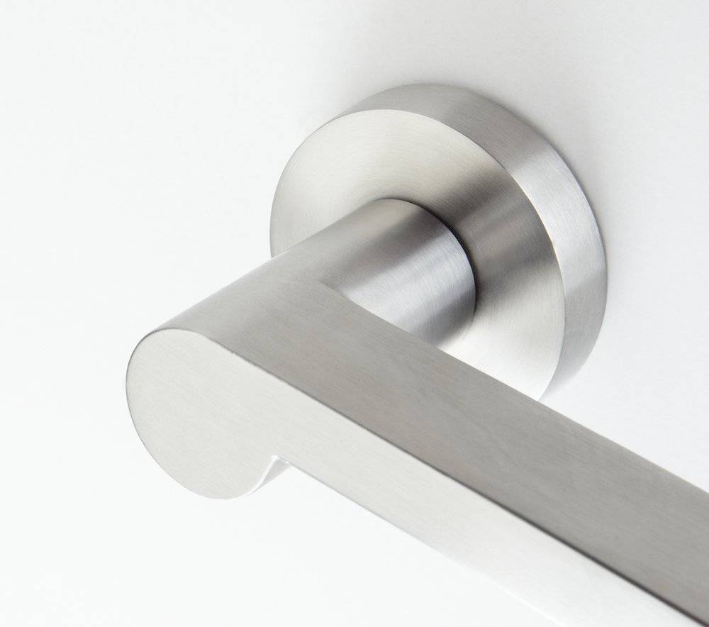 Ein Edelstahltürgriff, der an einer weißen Tür montiert ist, von einem Seitenwinkel gezeigt, wobei sein schlankes und modernes Design hervorgehoben wird.