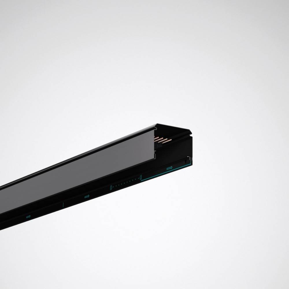 Eine schwarze, horizontal aufgehängte lineare Schienenbeleuchung vor einem schlichten hellgrauen Hintergrund, mit sichtbaren Kupferverbindern.