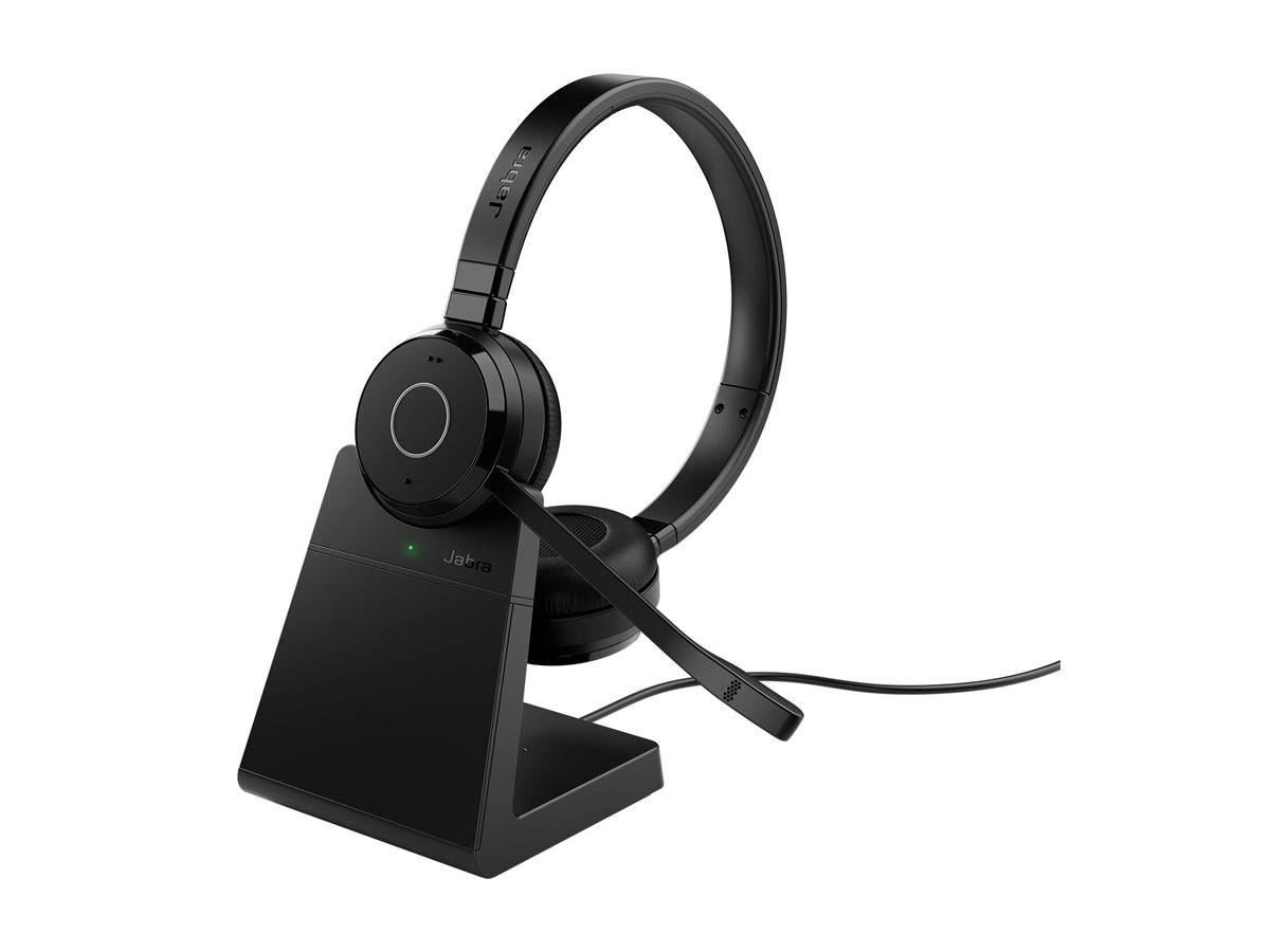 Ein schwarzes drahtloses Headset mit einem Auslegermikrofon ruht auf einem schlanken Ladegerät und zeigt ein grünes Ladenlicht.
