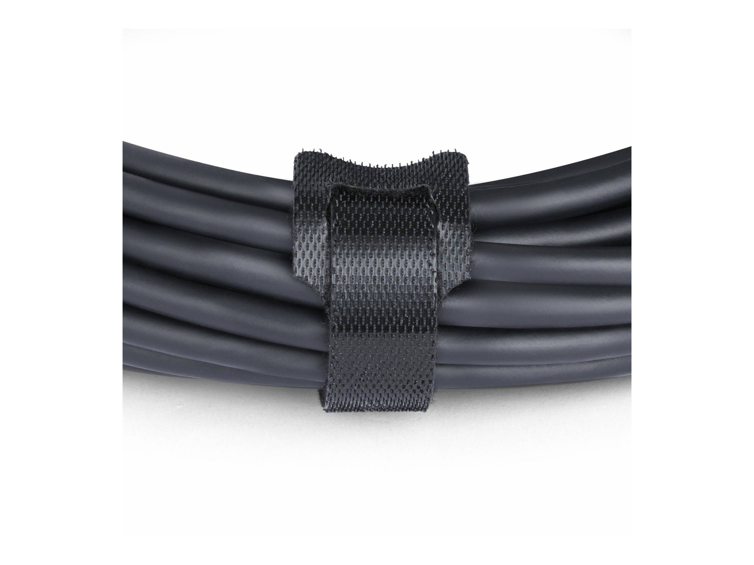 Ein schwarzes Kabel sauber aufgewickelt und mit einem schwarzen Klettband befestigt. Der Fokus liegt auf dem Klettband und dem Kabel und zeigt Organisationsfähigkeit.