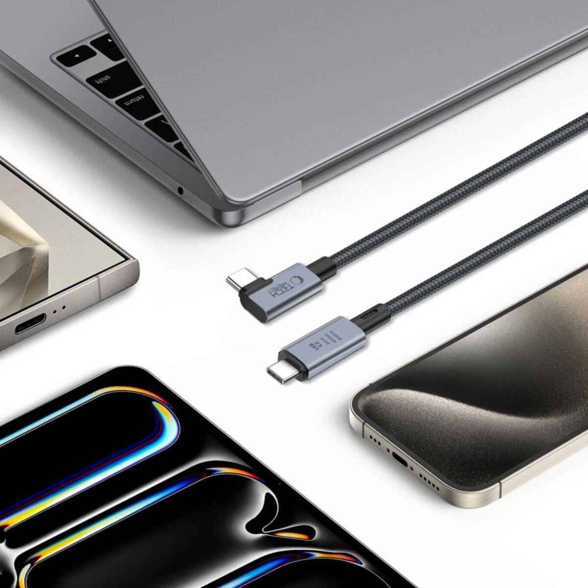 Laptops, Smartphones und Ladekabel auf einer weißen Oberfläche, die verbundene Technologie und Design präsentiert.