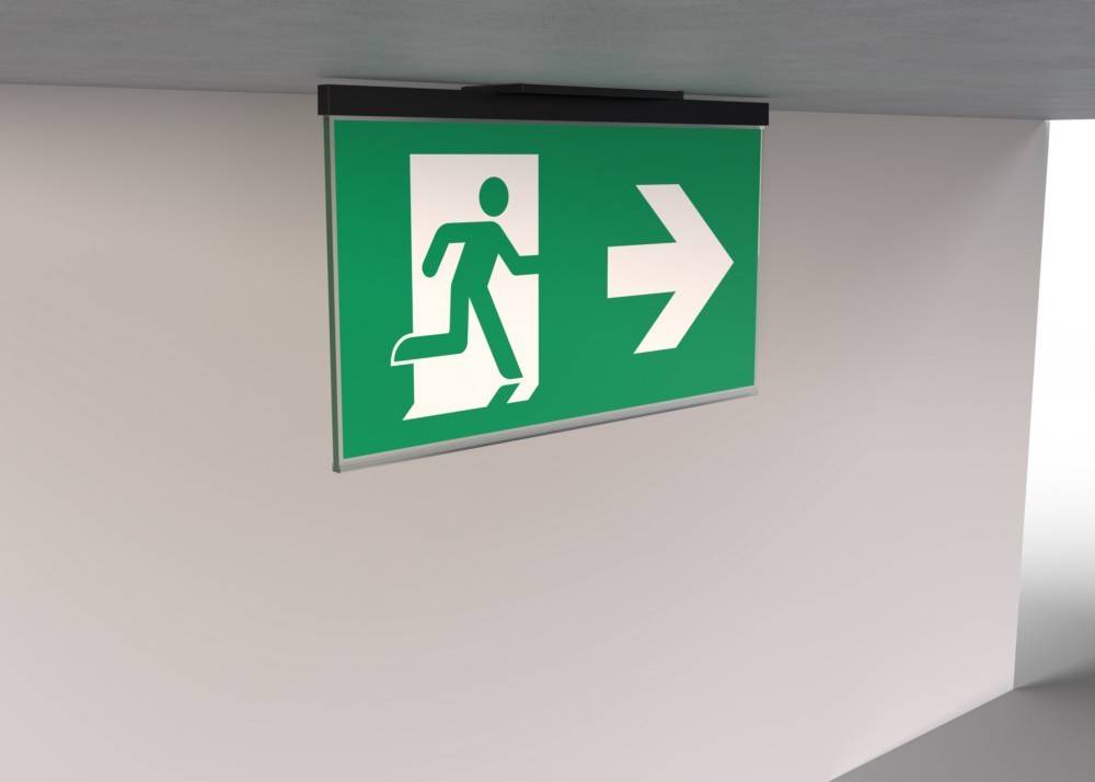 Ein grünes Notausgangsschild mit einer laufenden Figur und einem nach rechts weisenden Pfeil zeigt die Richtung zur Sicherheit.