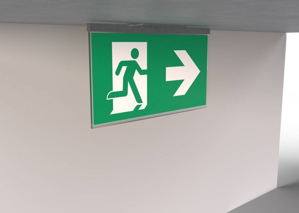 Grünes Notausgangsschild mit einer laufenden Figur und einem nach rechts weisenden Pfeil, der die Richtung des Fluchtwegs anzeigt.