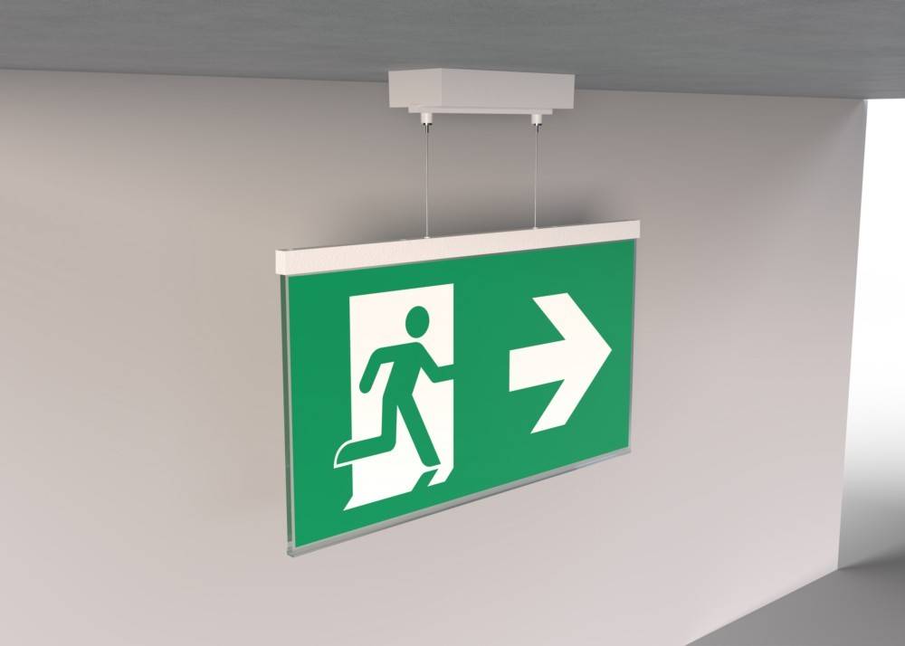 Notausgangsschild mit einer laufenden Figur und einem nach rechts weisenden Pfeil auf grünem Hintergrund, der die Richtung zum nächstgelegenen Ausgang anzeigt.