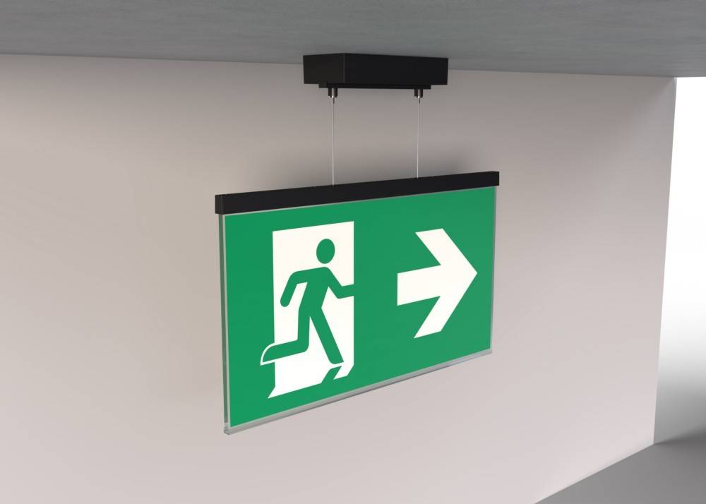 Fluchtwegeschild mit grünem Hintergrund, das eine Person zeigt, die rennend auf einen nach rechts weisenden Pfeil zusteuert und damit die Richtung des Notausgangs angibt.