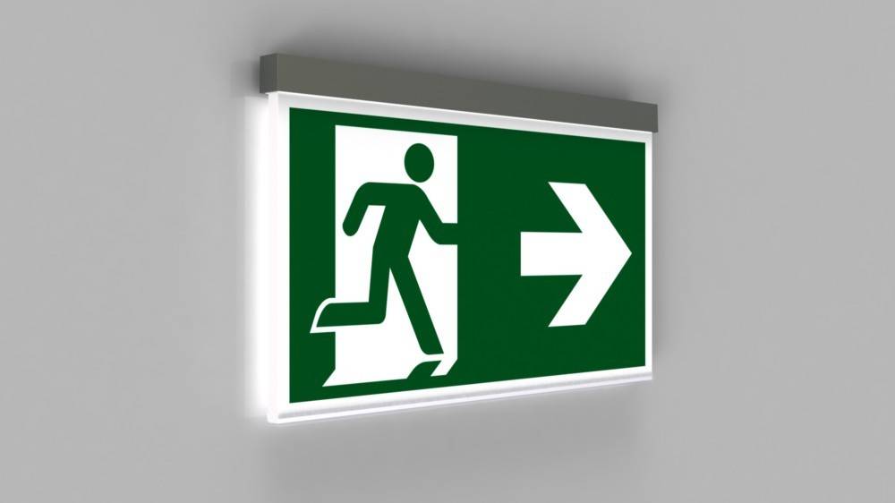 Notausgangsschild mit einer Figur, die nach rechts läuft und die Richtung zum Ausgang anzeigt.