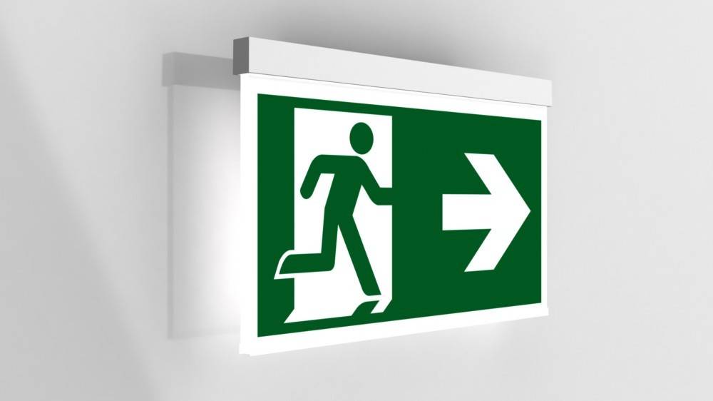 Ein grünes Notausgangsschild, das eine Person zeigt, die auf einen nach rechts weisenden Pfeil zulaufend darstellt und die Richtung für die Evakuierung angibt.