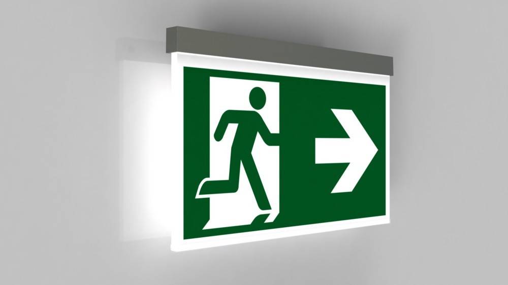 Fluchtwegeschild mit einer laufenden Figur, die auf einen nach rechts weisenden Pfeil zusteuert und damit den Richtungsweg zum Notausgang anzeigt.