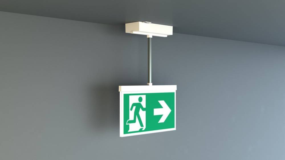 Ein Notausgangsschild mit einer laufenden Person und einem Pfeil, der nach rechts zeigt, der die Richtung zum nächstgelegenen Ausgang anzeigt.