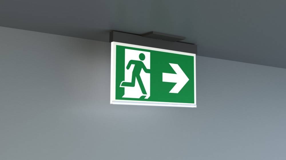 Grünes Ausgangschild mit einer laufenden Figur und Pfeil nach rechts, das die Richtung zum Notausgang anzeigt.