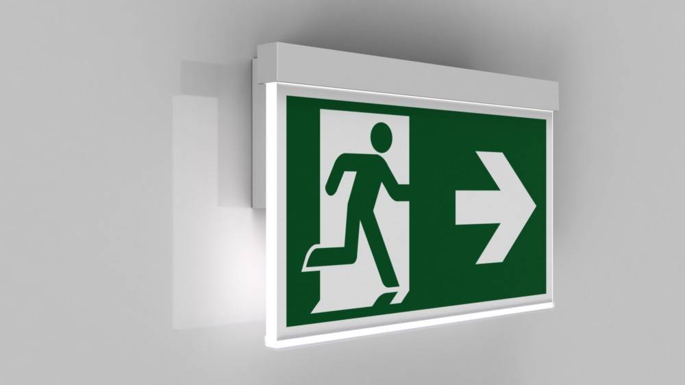 Notausgang-Schild mit einer Figur, die durch eine Tür läuft und nach rechts zeigt, um die Richtung zum nächstgelegenen Ausgang anzuzeigen.