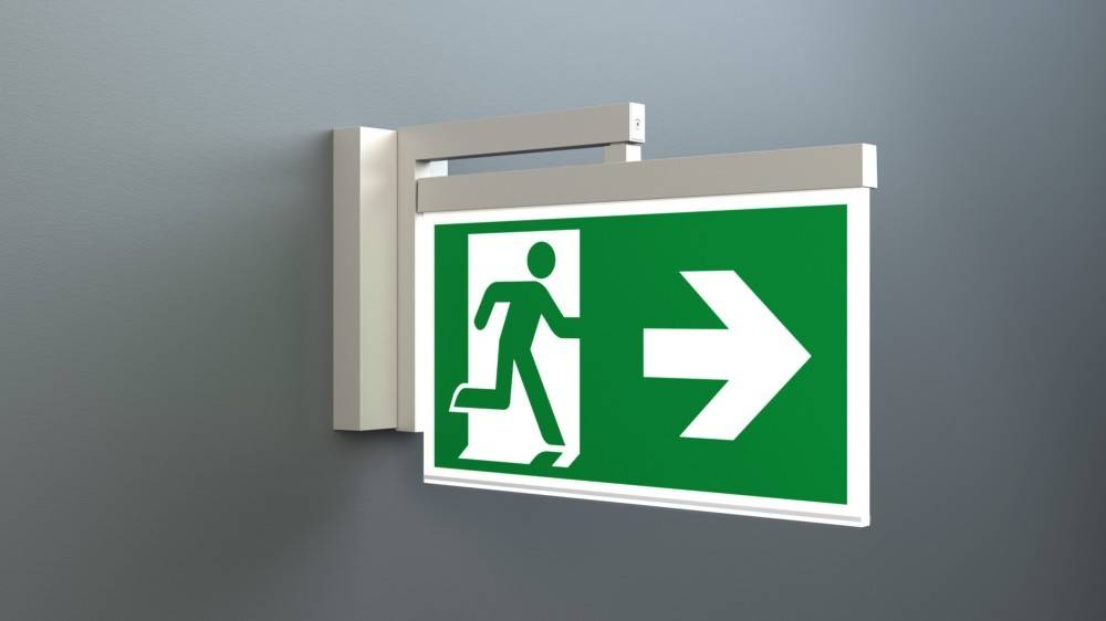 Notausgangsschild mit einer Figur, die durch eine Tür läuft, und einem Pfeil, der nach rechts zeigt, der die Richtung zum Notausgang angibt.