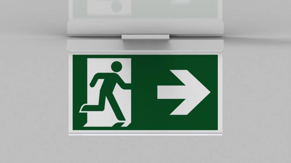 Grünes Notausgangsschild mit einer laufenden Figur und einem nach rechts weisenden Pfeil, der die Richtung zum nächstgelegenen Ausgang anzeigt.