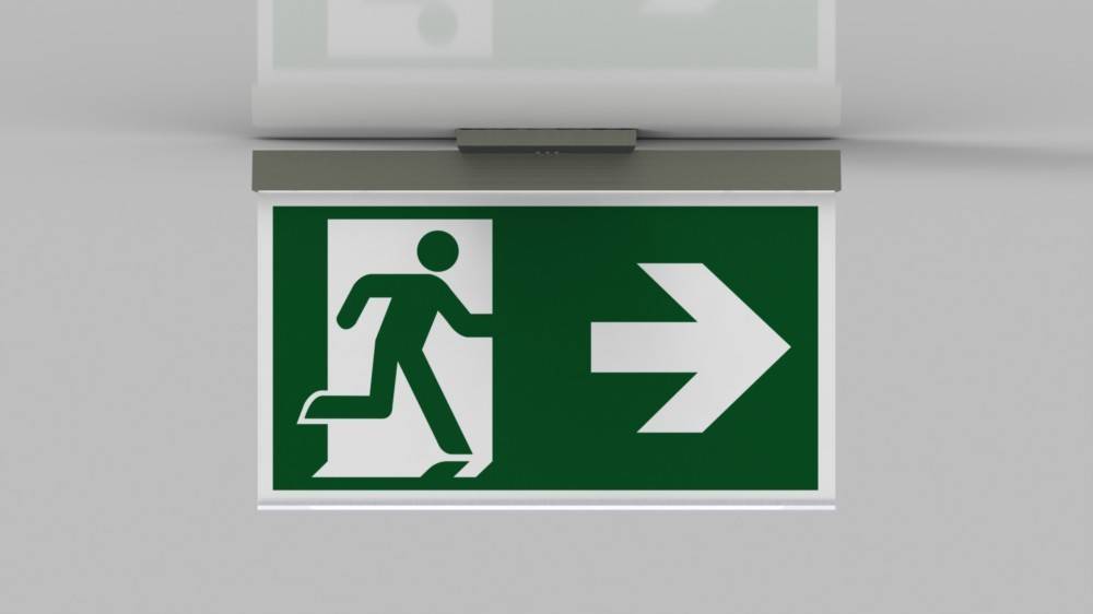 Grünes Notausgangsschild mit weißer Figur, die durch eine Tür läuft und von einem nach rechts weisenden Pfeil begleitet wird, der die Richtung des Notausgangs anzeigt.