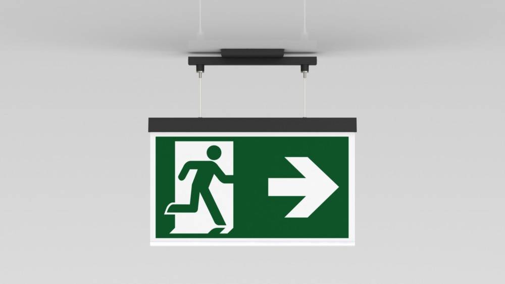 Fluchtzeichenschild mit einer laufenden Figur, die auf eine Tür und einen nach rechts weisenden Pfeil zuläuft, der die Richtung des Notausgangs anzeigt.