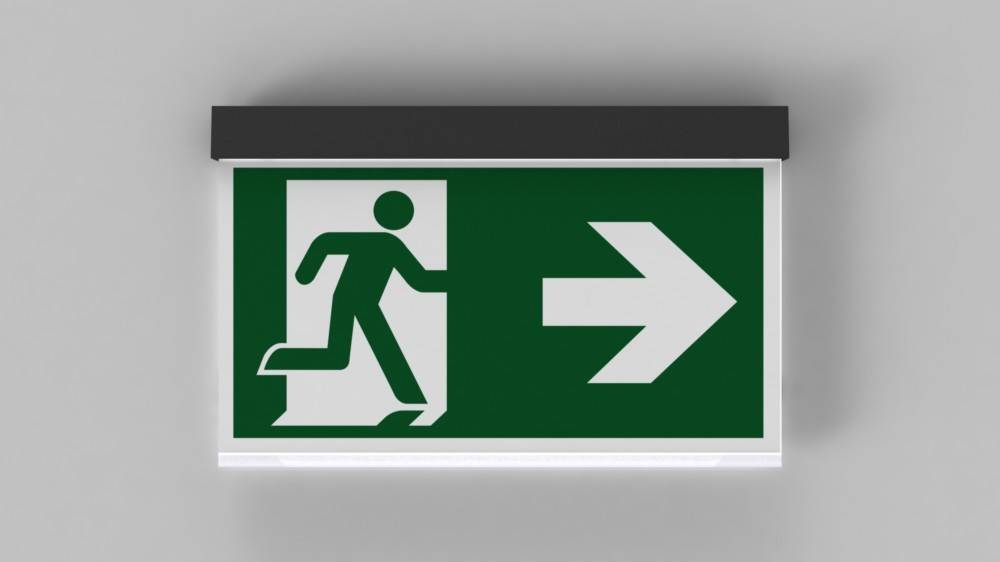 Grünes Notausgangsschild mit einer laufenden Person in Richtung eines nach rechts zeigenden Pfeils, der die Richtung zum Ausgang anzeigt.