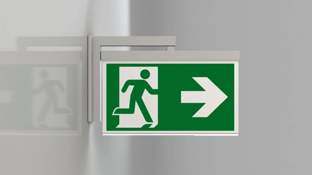 Notausgang-Schild mit einer laufenden Figur und einem Pfeil, der nach rechts zeigt und die Richtung zum Ausgang angibt.