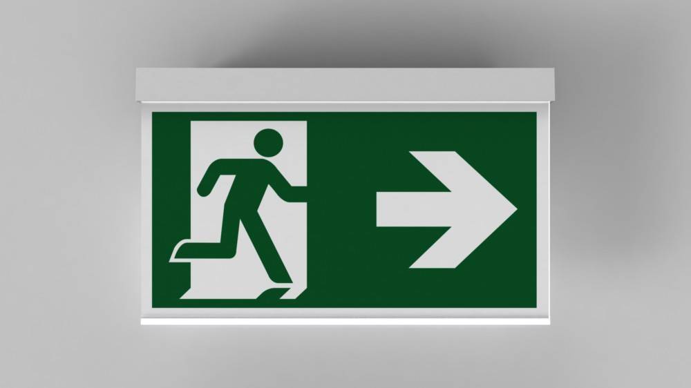 Grünes Notausgangsschild mit einer weißen Figur, die auf einen nach rechts weisenden Pfeil zulaufend die Richtung zum Ausgang anzeigt.