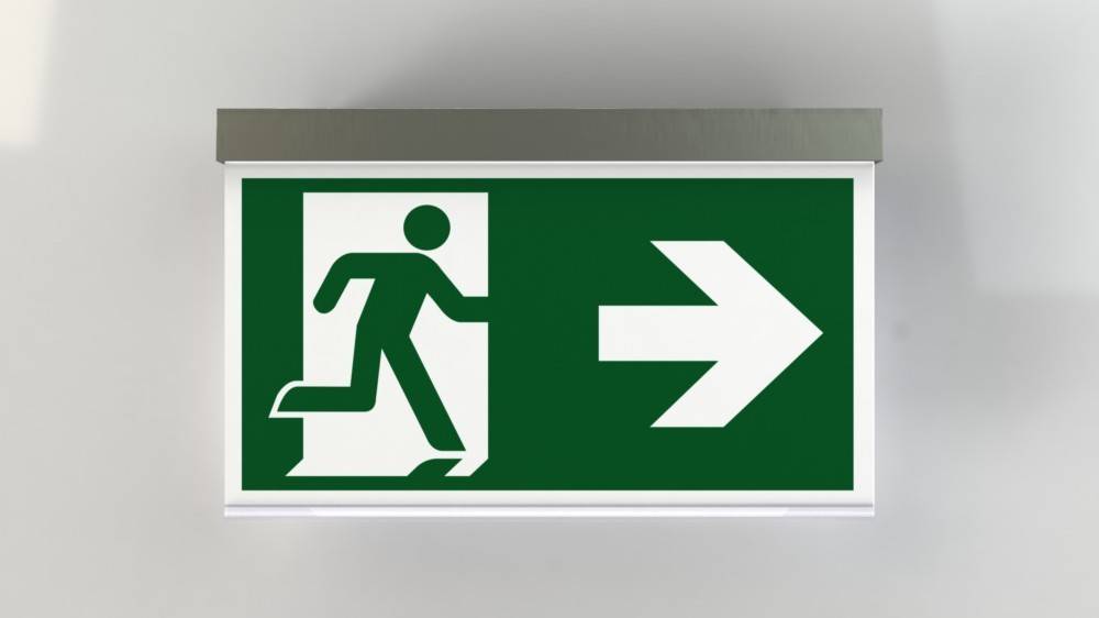 Notausgangsschild mit einer laufenden Figur, die durch eine Tür geht, mit einem großen Pfeil, der nach rechts zeigt und die Richtung des Ausgangs angibt.