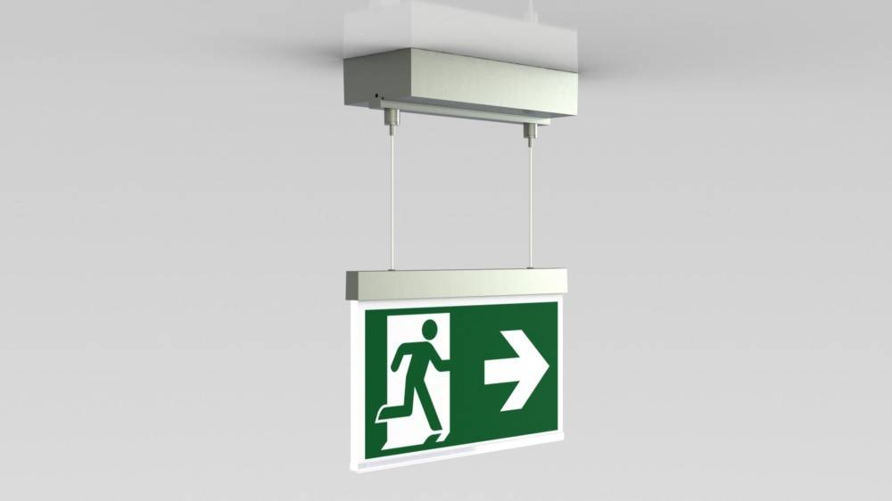 Ein grün-weißes Notausgangsschild, das von der Decke hängt und eine Person zeigt, die auf einen nach rechts weisenden Pfeil zuläuft, der die Richtung des Notausgangs angibt.