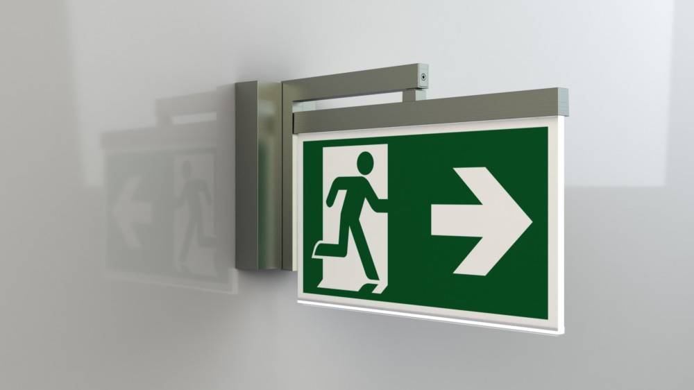 Notausgangsschild mit einer Person, die durch eine Tür läuft, mit einem nach rechts weisenden Pfeil, der die Fluchtrichtung anzeigt.