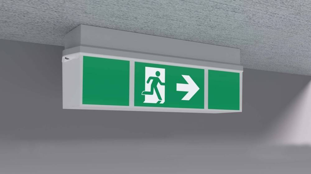 Fluchtwegeschild mit einer laufenden Figur und einem nach rechts weisenden Pfeil auf grünem Hintergrund, das die Richtung zum nächstgelegenen Ausgang anzeigt.